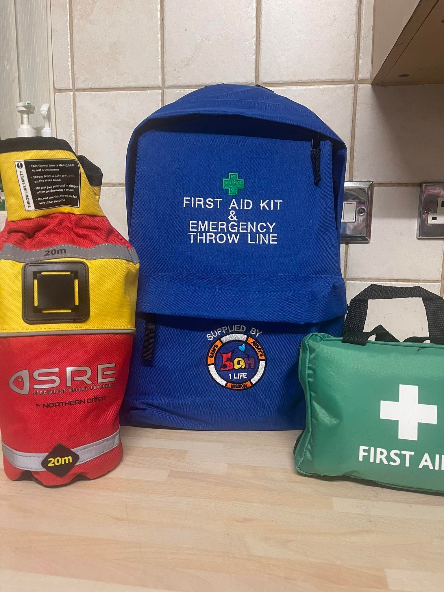 A red 20-metre throwline bag beside a blue emergency first-aid and throwline backpack supplied by Sam's Army